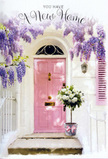 This photograph captures the quiet elegance of a Surrey home's entrance, styled to celebrate the joy and promise of moving into a new place. At the centre, a pastel pink door stands tall, its smooth, matte paint lending it a refined yet friendly presence against the surrounding whitewashed wall. The simplicity of the architecture allows the flowers to take centre stage. From above the doorway, cascades of wisteria in shades of lavender and soft purple drape down in loose, fragrant clusters, each blossom-laden stem catching the light and creating a soft, romantic canopy. The wisteria frames the door with natural curves and shadows, suggesting the kind of mature climber you might find in long-loved Surrey gardens in villages such as Godalming or Haslemere. On the doorstep, a tall, understated tin bucket in gentle grey rests solidly on the stone. It is filled generously with creamy white and ivory roses, their lush, velvety petals arranged in a way that feels both abundant and carefully considered. Nestled among the roses are sprigs of fresh green foliage that add texture and a hint of woodland freshness. Around the bucket's base, a blush pink ribbon is tied loosely, the satin bow echoing the door's soft shade and adding a subtle note of celebration. Sunlight filters through the curtain of wisteria overhead, falling in dappled patterns across the step and creating a sense of depth and intimacy. The entire scene feels welcoming and hopeful, as if a thoughtful florist has left this arrangement to greet new homeowners at the end of a long day of unpacking. It's a visual promise that within these walls, life in Surrey will be filled with warmth, friendship, and the quiet comfort of coming home to flowers.